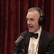 Jordan Peterson wearing a bow tie and talking into a microphone.